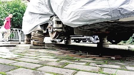 夫妻拆卸路边小车轮胎 打算替换自家车辆旧胎