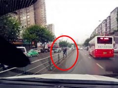 大妈翻越隔离护栏   车流中横穿马路