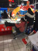 女子蜷坐购物车内逛超市 背后还有人推着跑