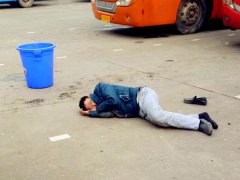 男子躺在地上鞋丢一边  旁边还有垃圾桶